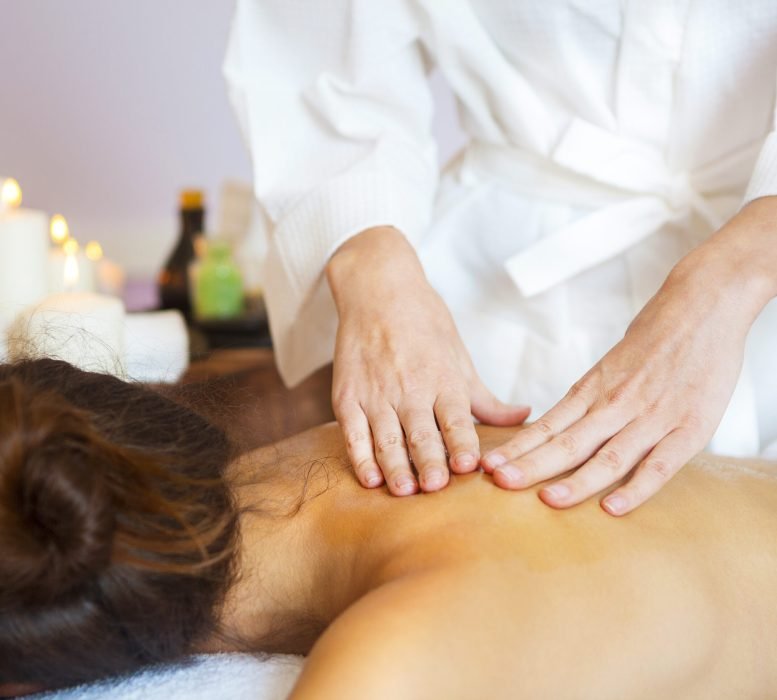 Beautiful young woman relaxing with hand massage at beauty spa. Close up